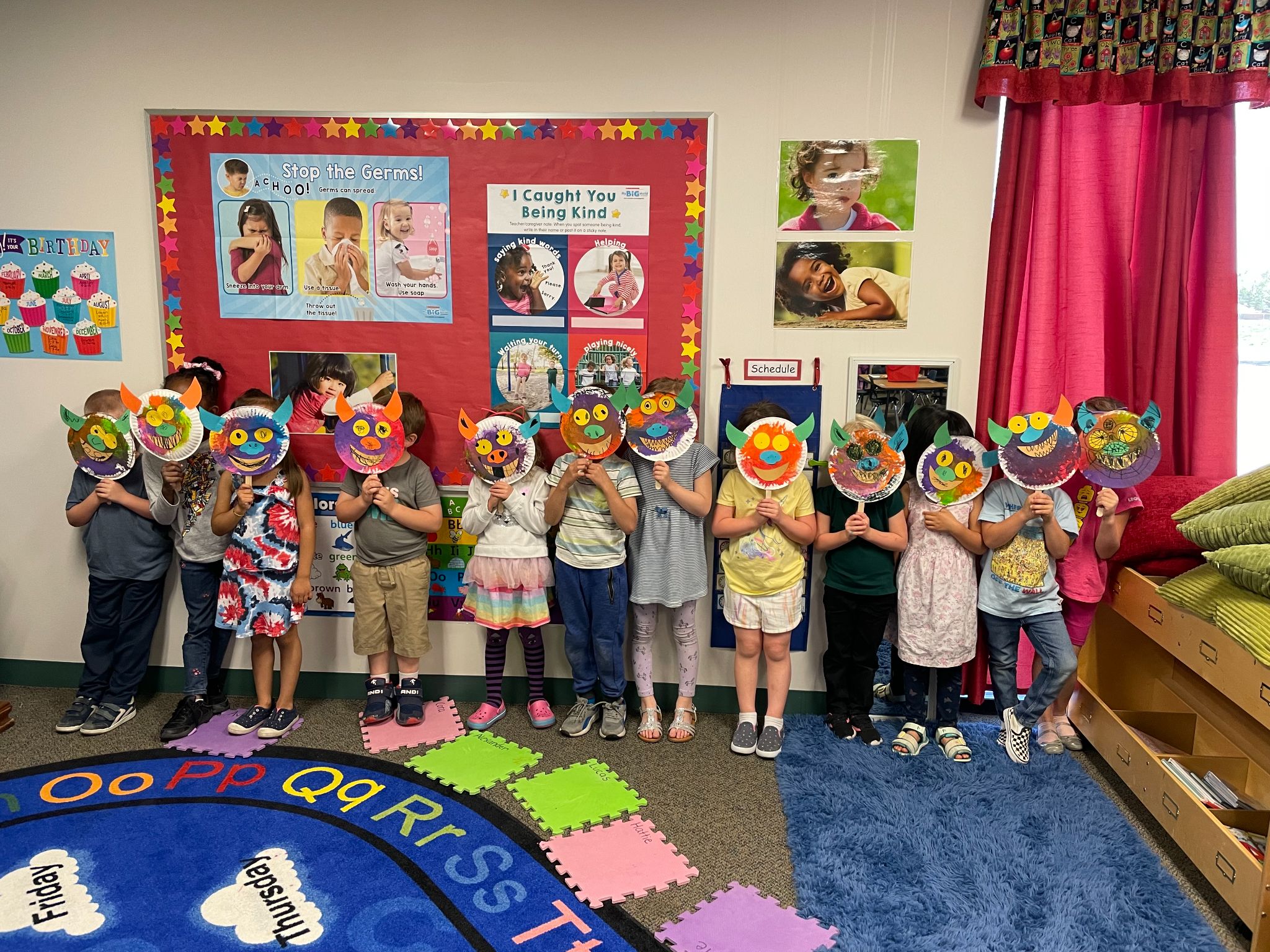 PreK holding paper plate masks over faces in a line