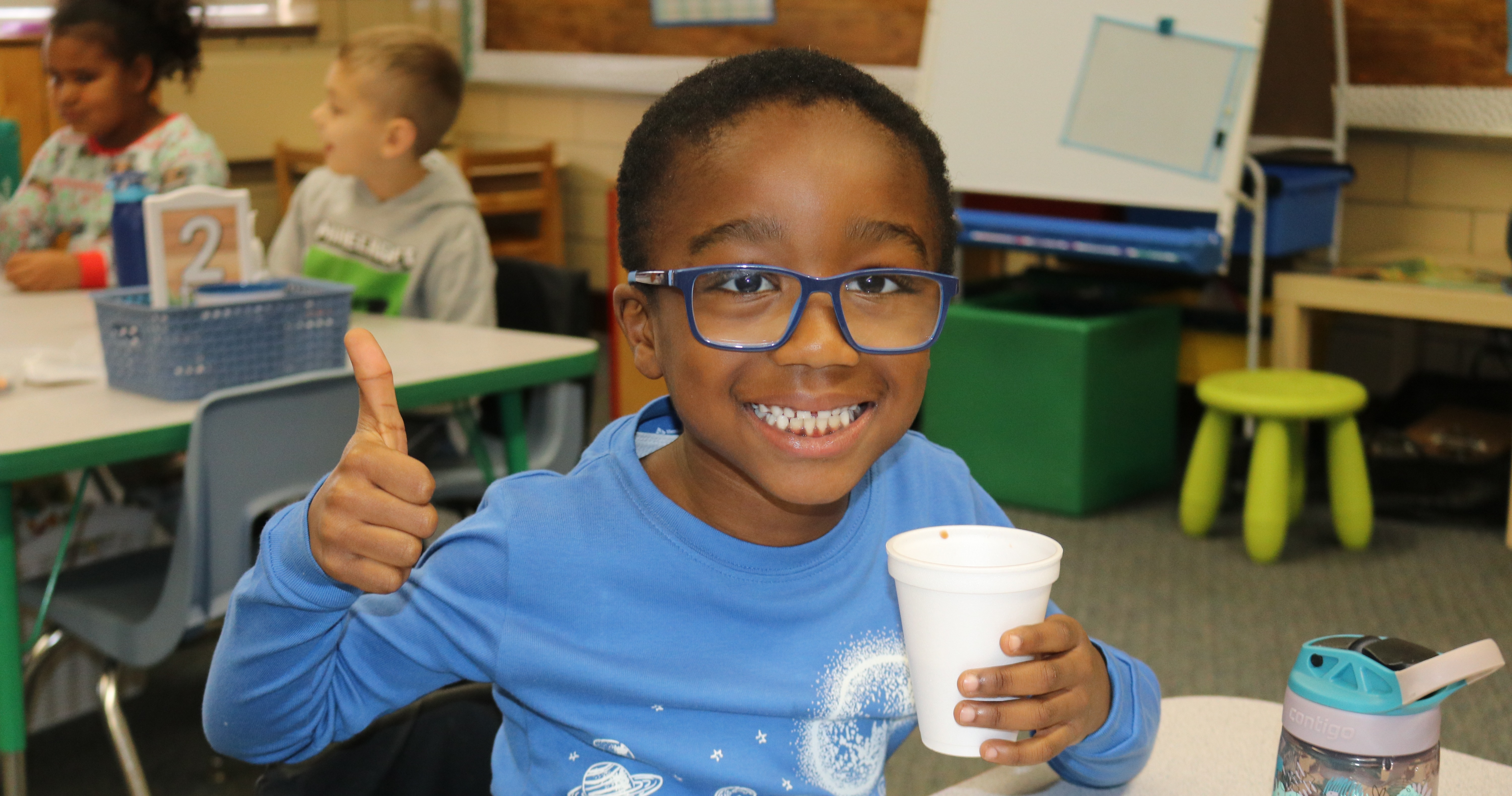 A students gives a thumbs up for his hot chocolate.