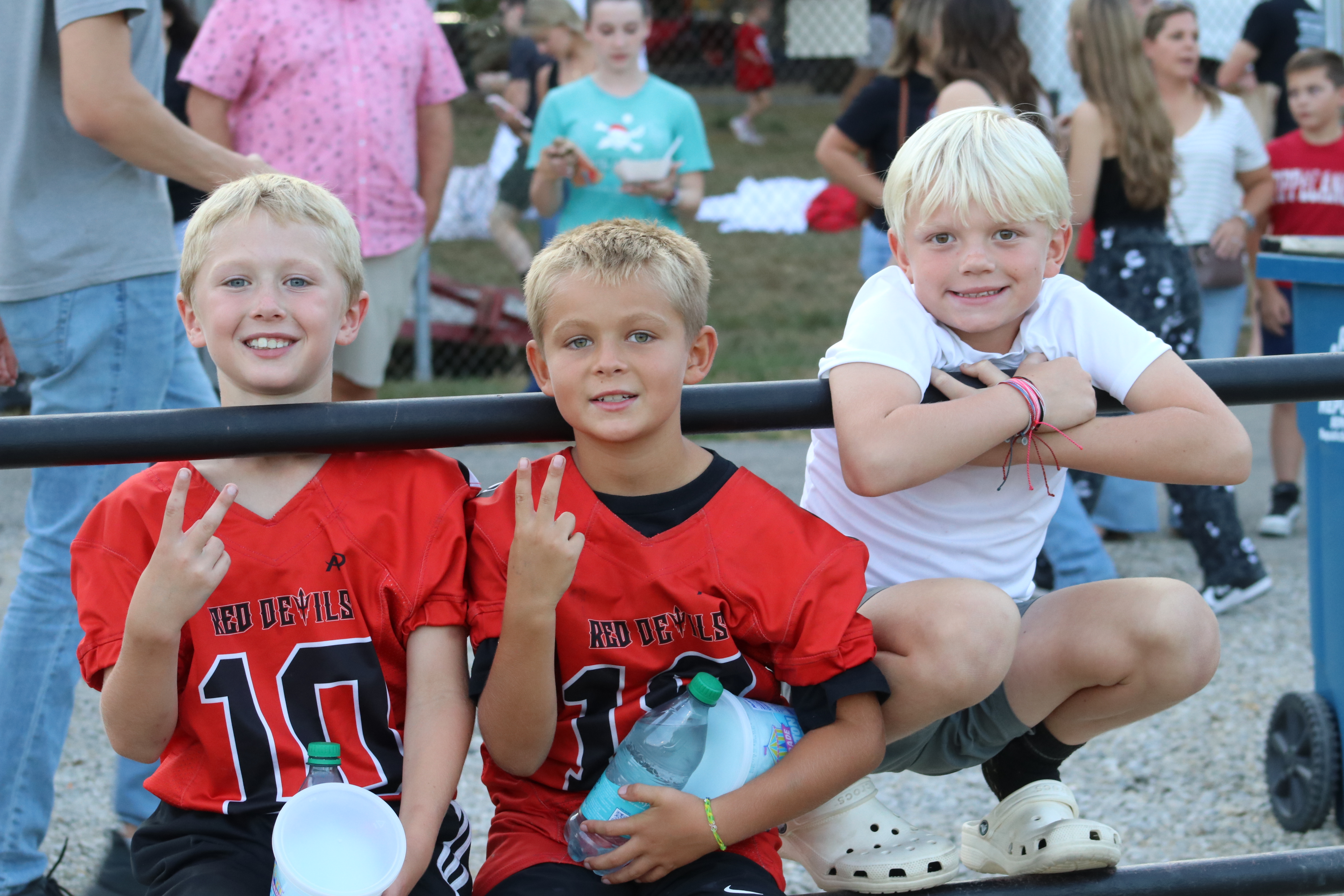 Three young boys at the football game.