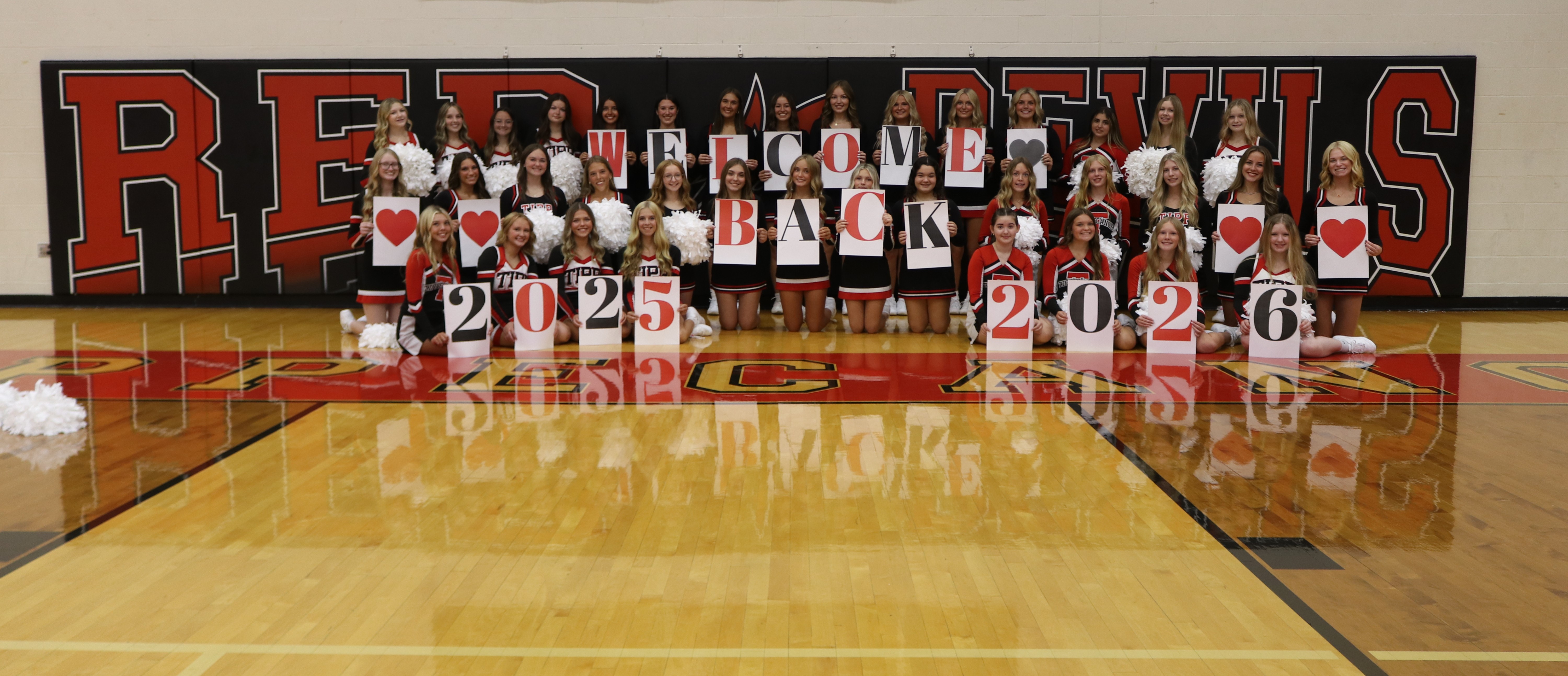 Cheerleaders pose with Welcome Back!