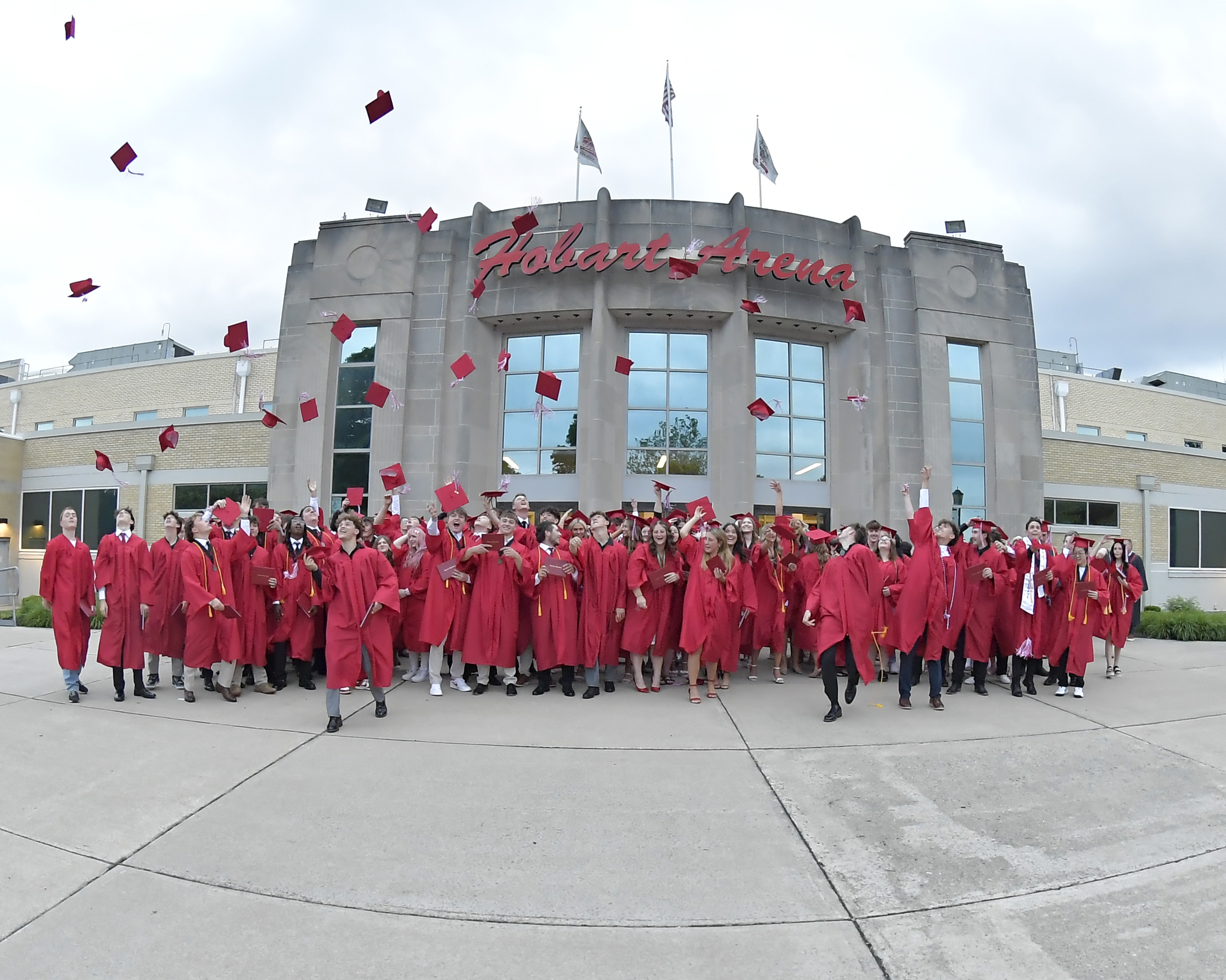 Class of 2026 toss up their caps after graduation.