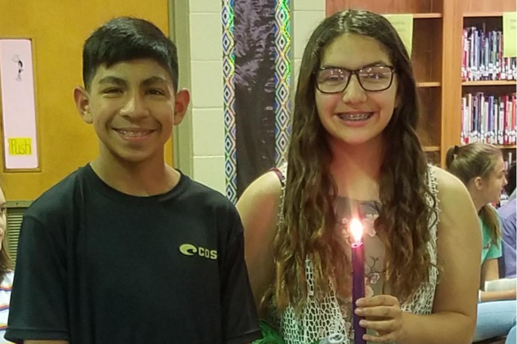 2 students posing with a candle
