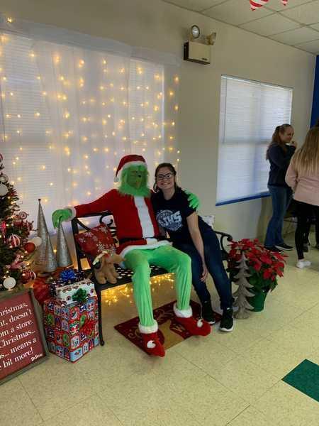 Student posing with the Grinch