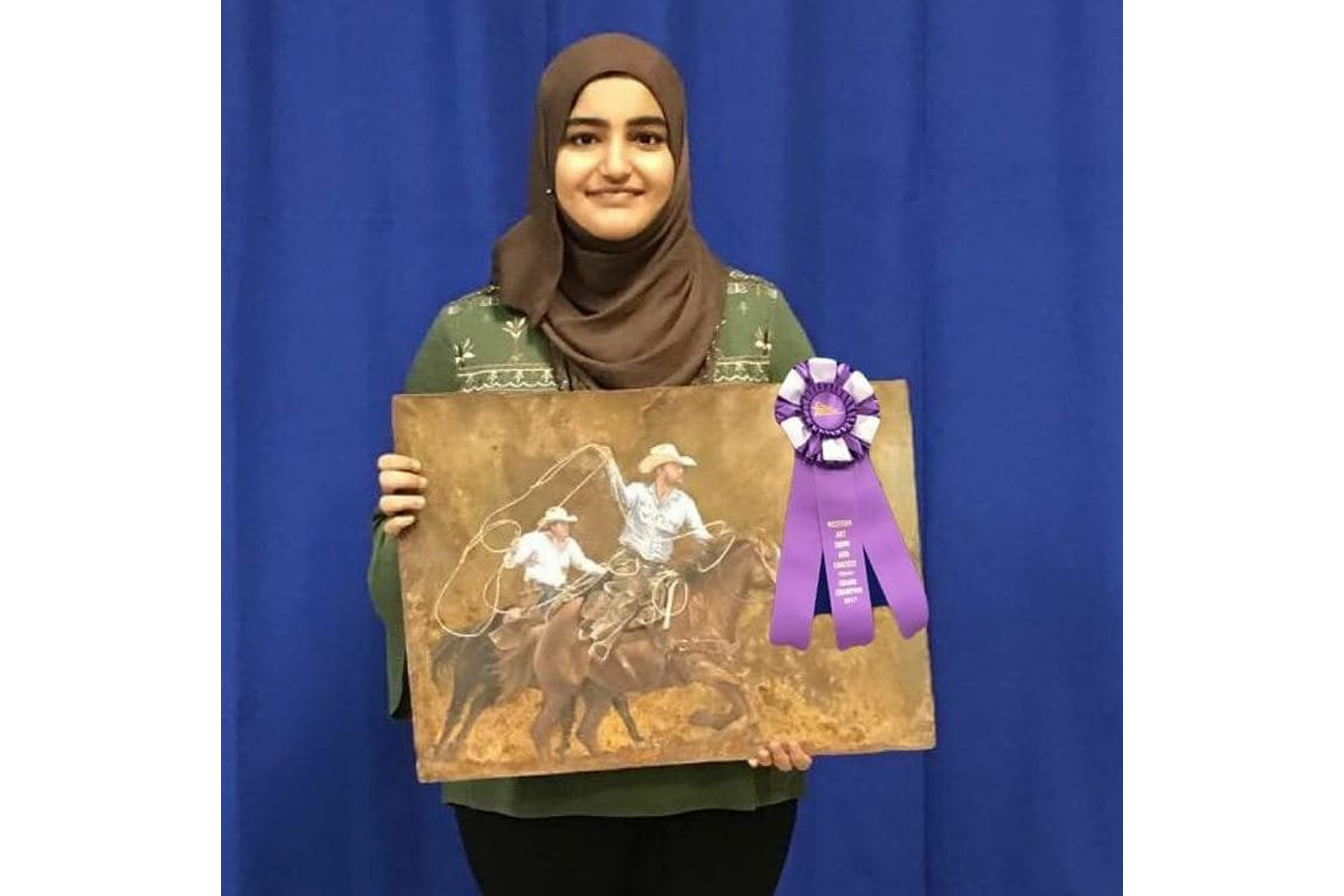 Student with her artwork and a ribbon