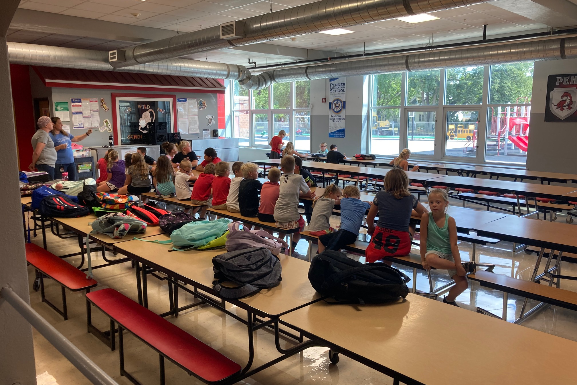 students sitting in the Pender cafeteria listening to their teachers
