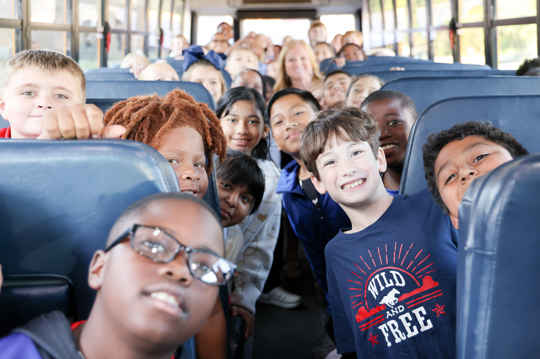 Students smiling on bus
