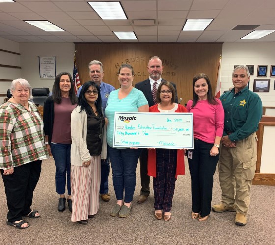 A group of people holding a large check