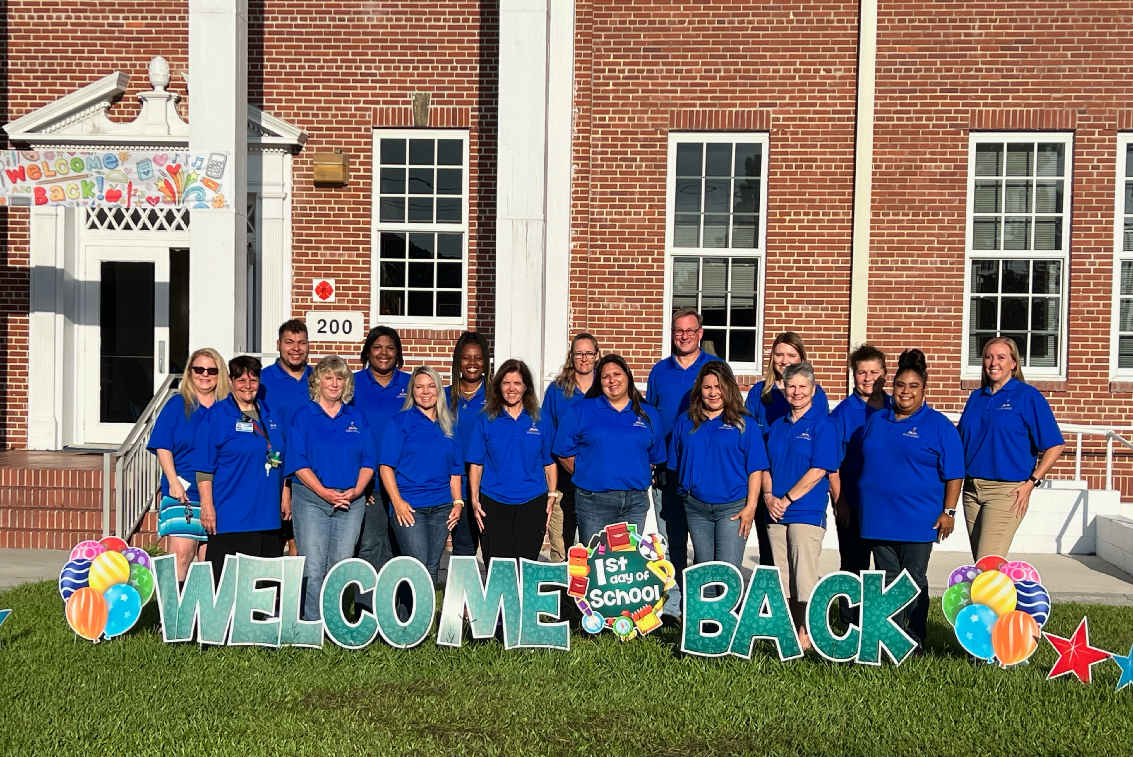 ESE STAFF wearing blue shirts with a Welcome Back sign