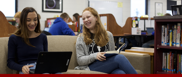 Two students in their library smiling and laughing