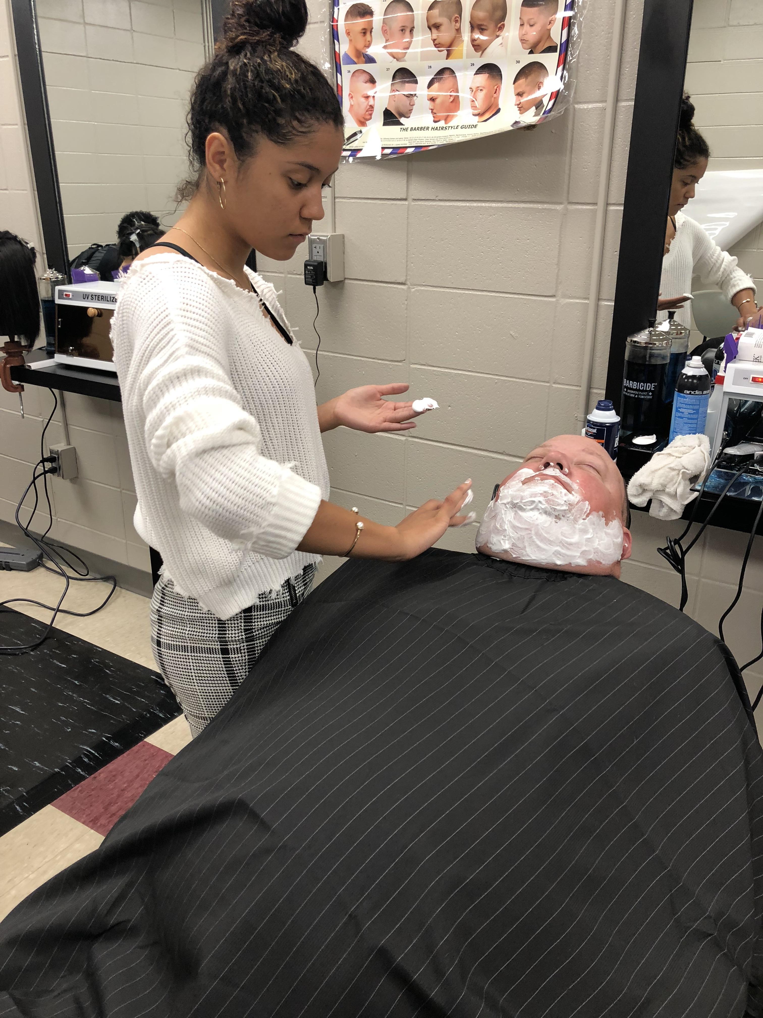 Mr. Cobb getting his face shaved by a cosmetology student