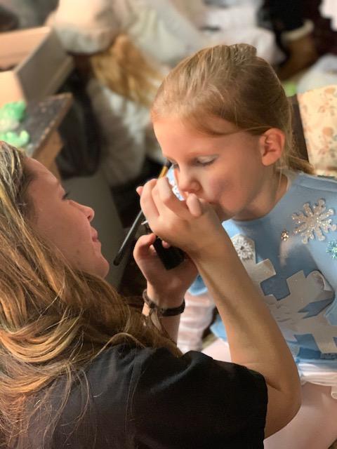 Cosmetology student doing young girl's makeup