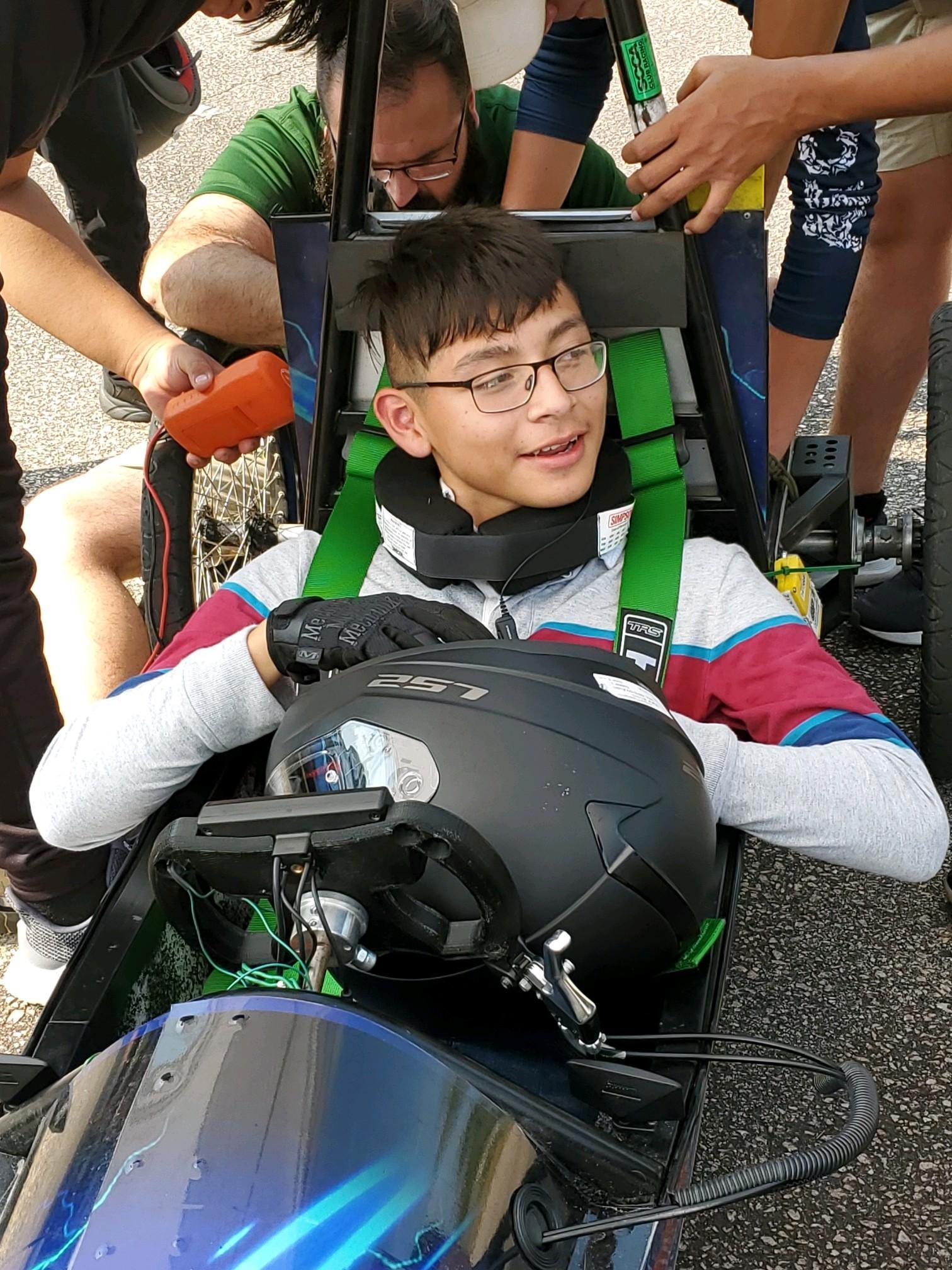 Student sitting in small vehicle getting ready for the race