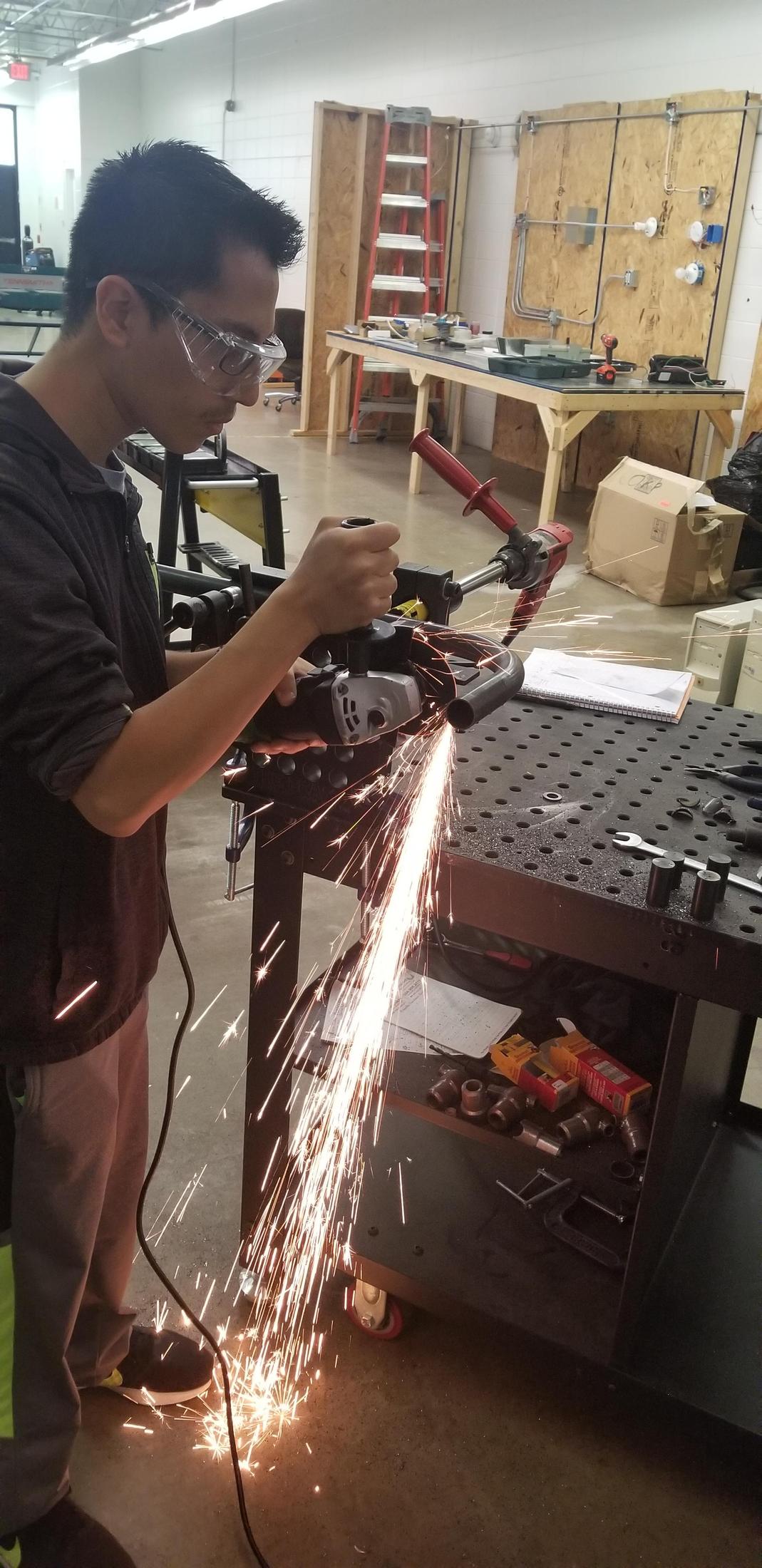 Student using equipment to cut metal