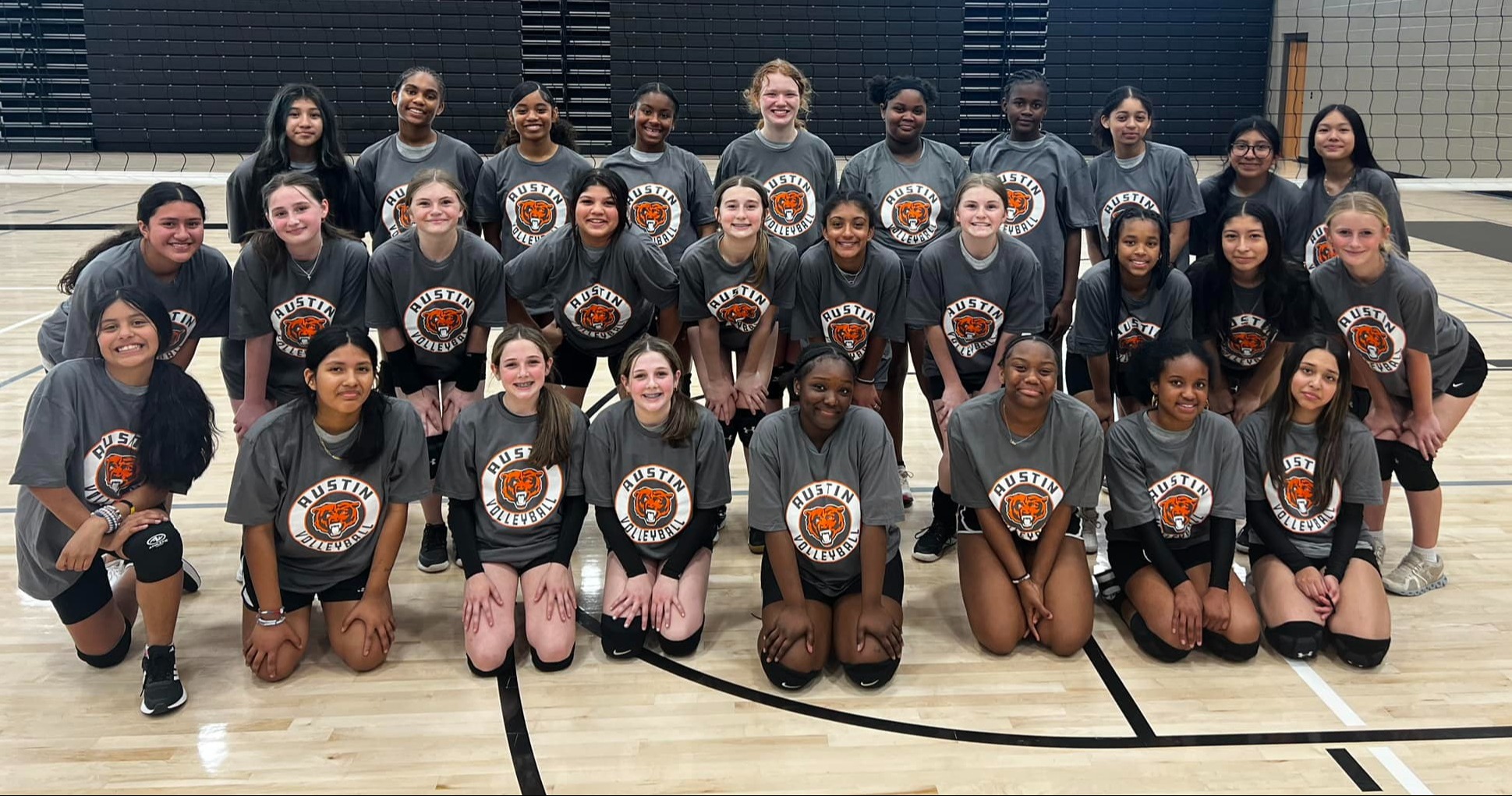 Austin Junior High's volleyball team poses on the gym floor for a group photo.