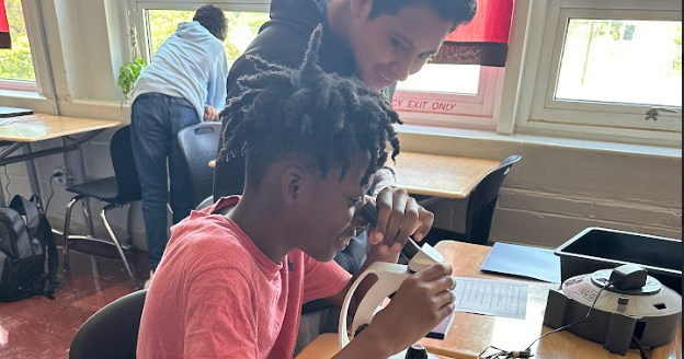 Image of 7th grade Science students at DMS using a microscope in class.