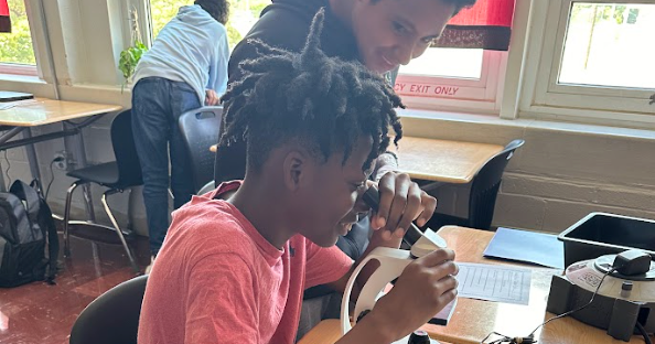 Image of 7th grade Science students at DMS using a microscope in class.
