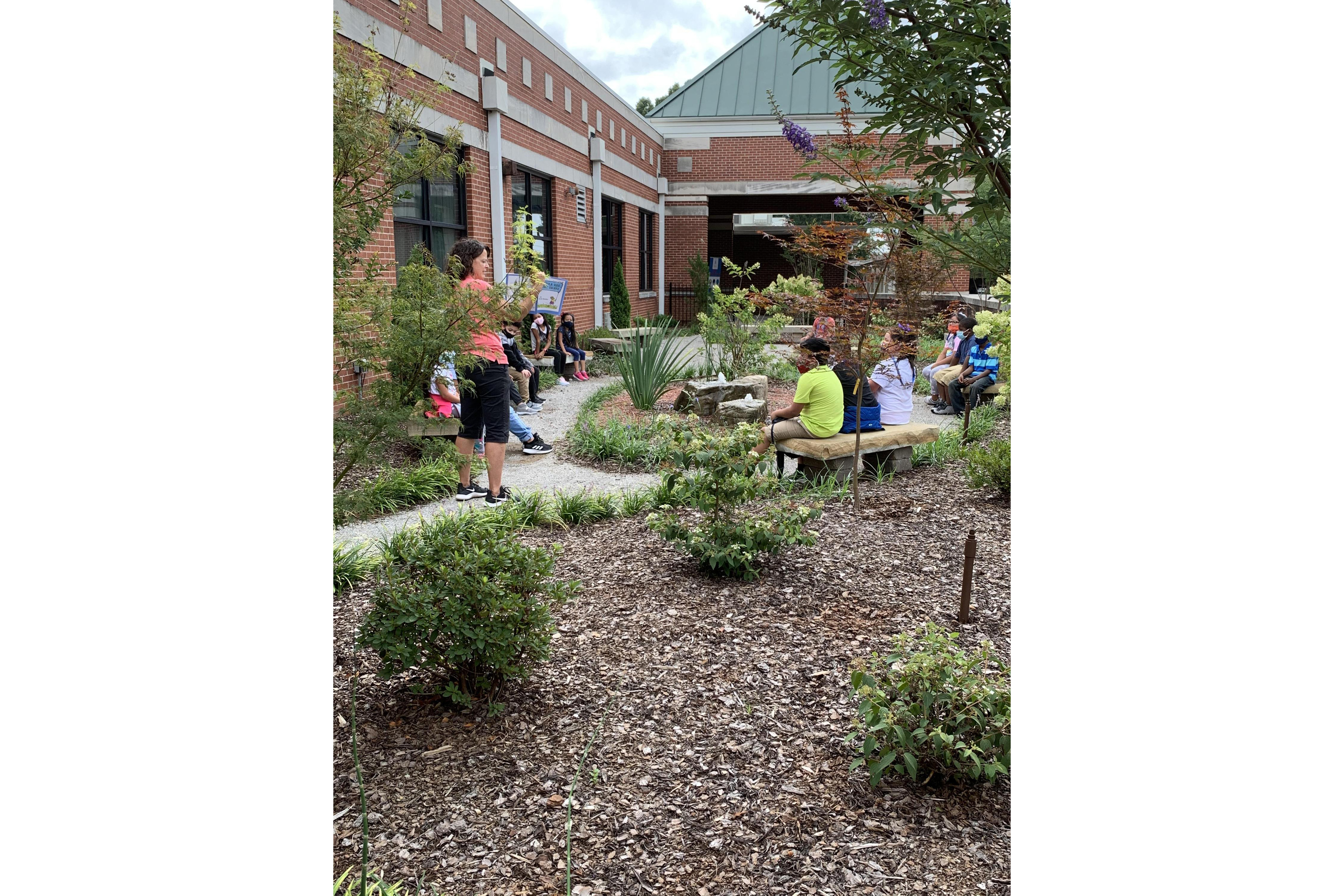 Teacher reading to students in the garden