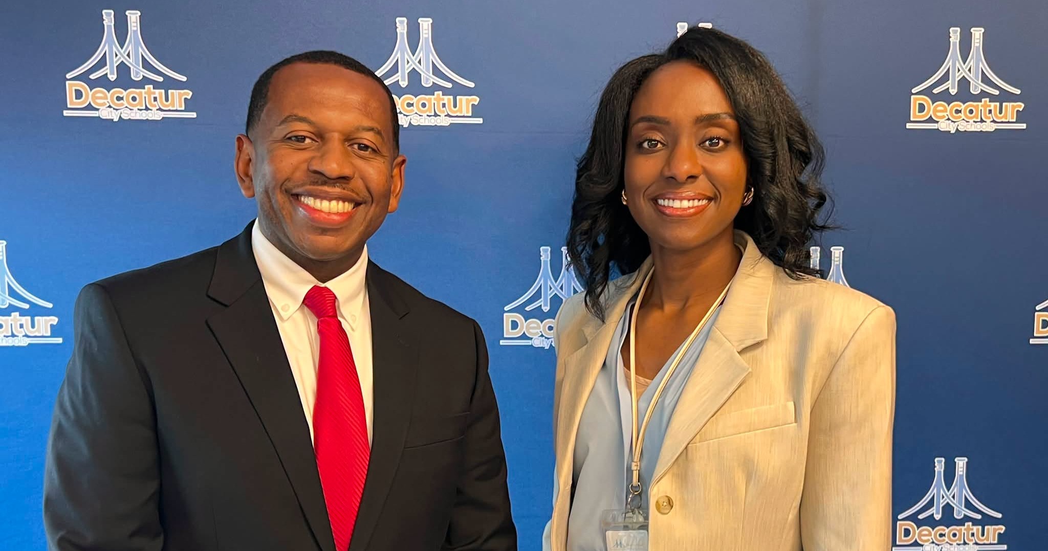 Cory Muhammad joins Principal Nia Strong as West Decatur Elementary's Assistant Principal. The two pose together in front of the blue Decatur City Schools background.