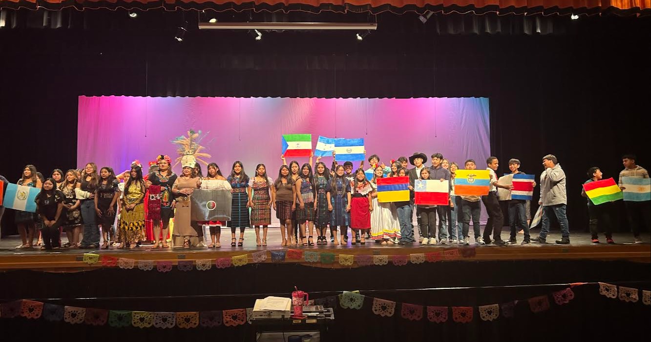 Students hold flags to represent various Spanish-speaking countries at Austin Junior High School's Hispanic Heritage celebration.