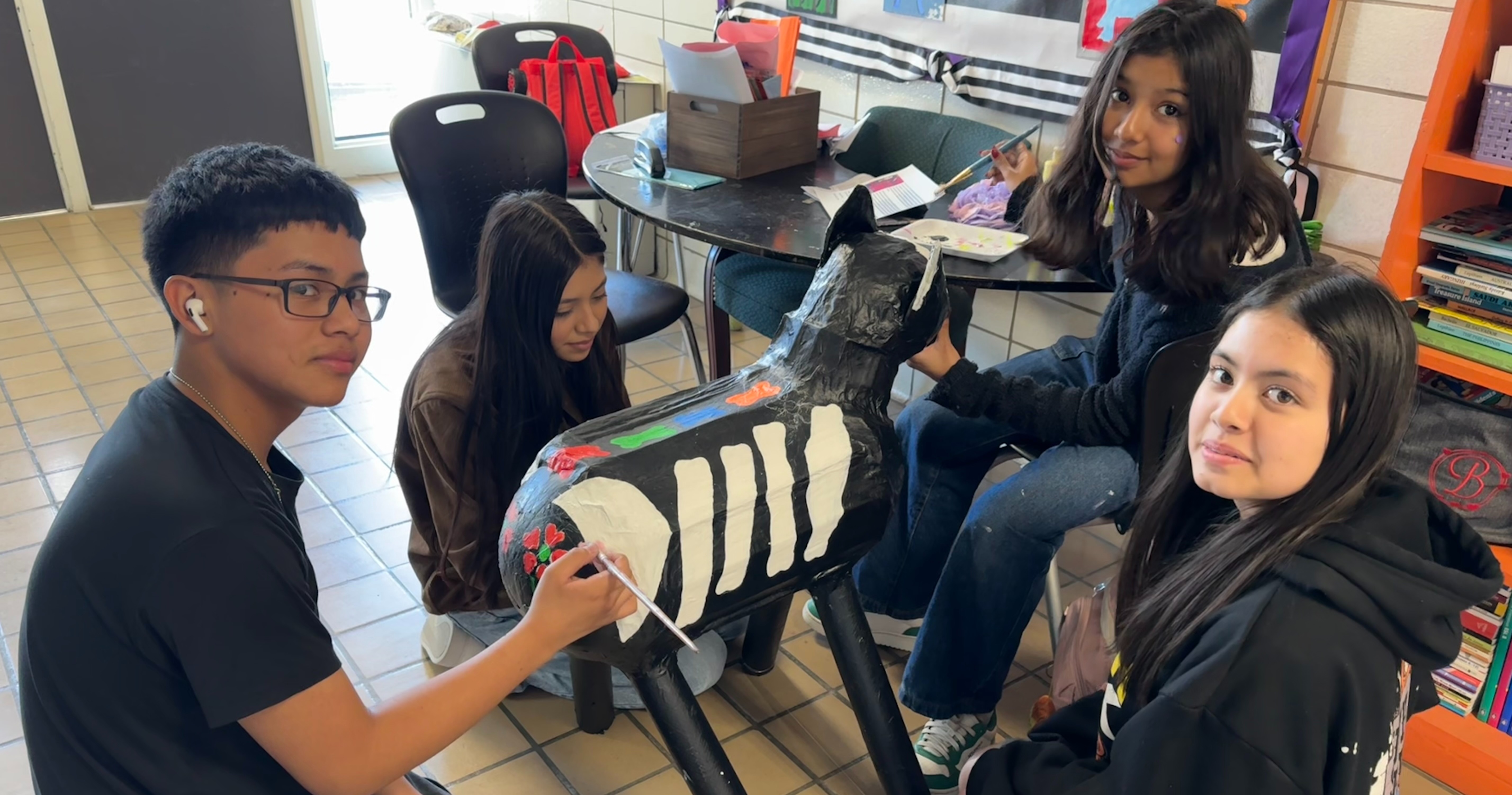 Students at The Excel Center paint a skeletal papier-mache horse to display at the day of the dead celebration