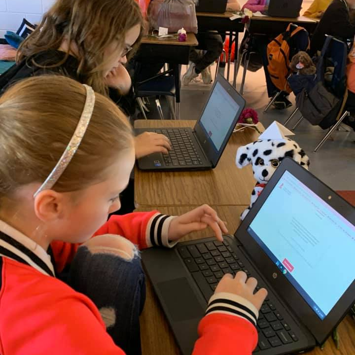 Students collaborate on individual chromebooks in classroom