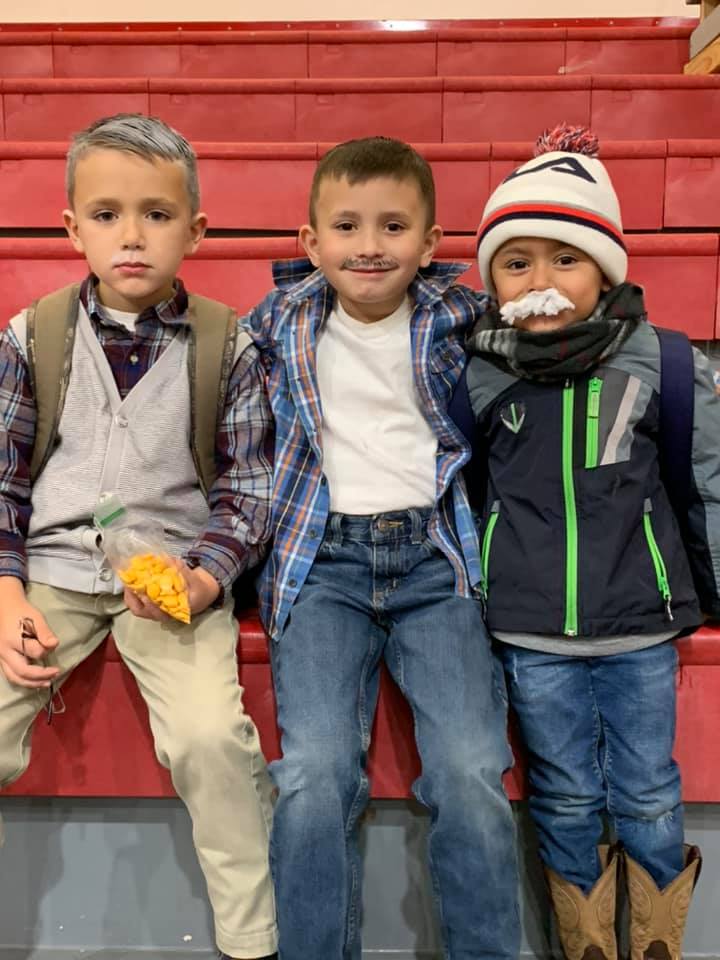 Three elementary boys grinning in their "100 day of school" outfits