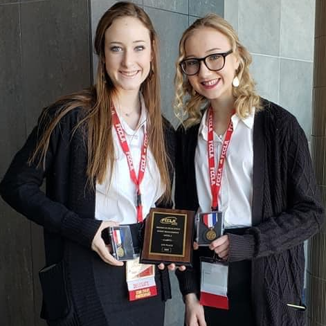 Two girls pose with awards
