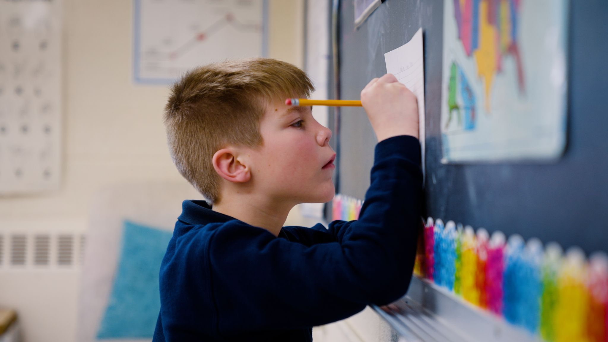 child writing on chalk board