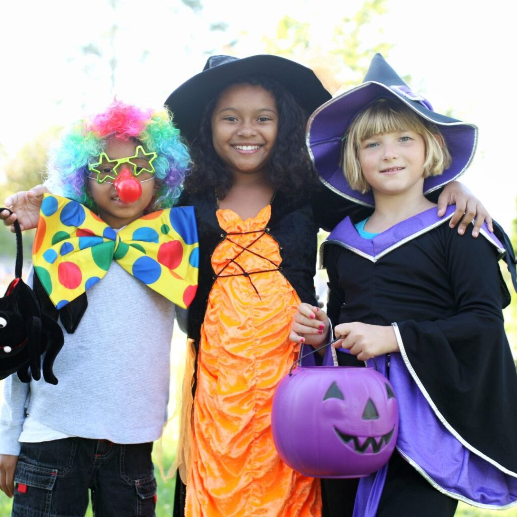 3 children in Halloween costumes.
