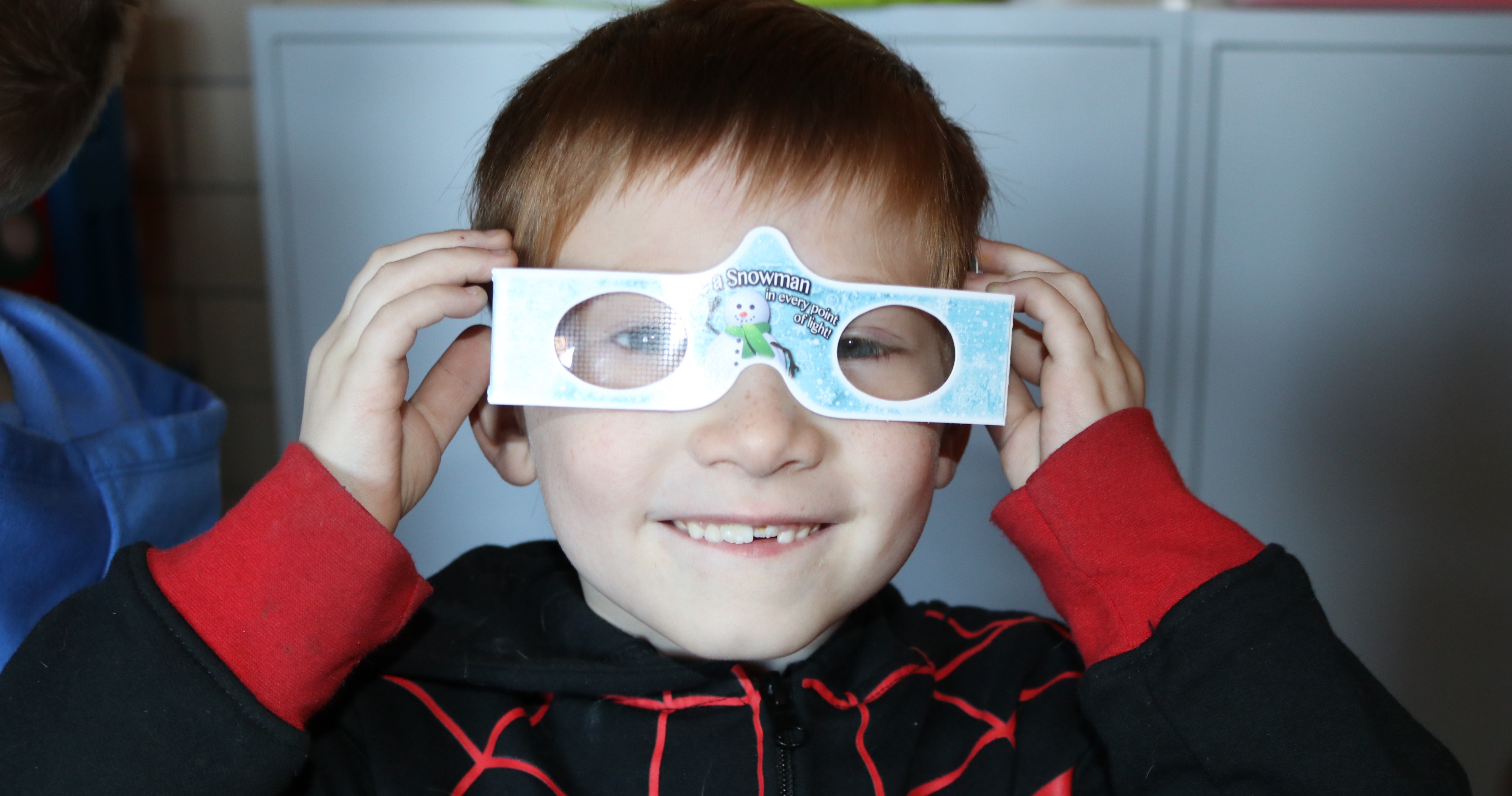 A little boy wearing silly glasses