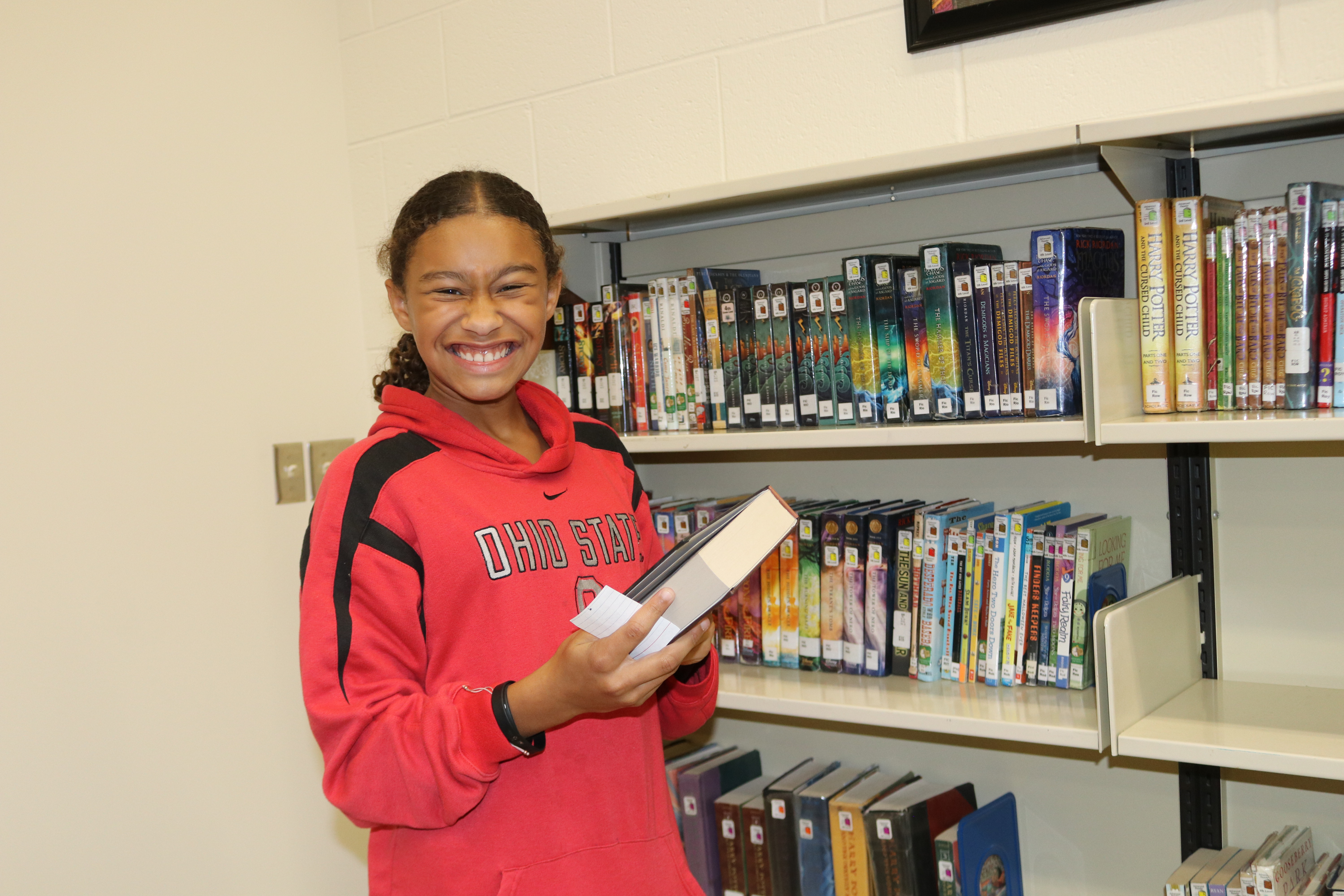 A very happy L.T. Ball student selecting a book at the library.