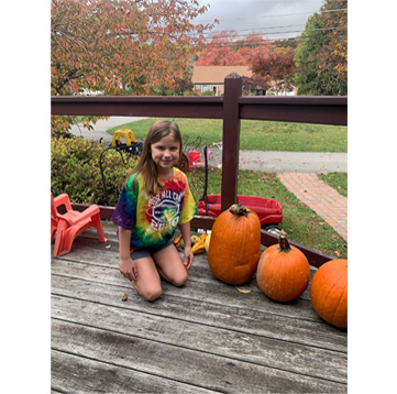 Student posing with pumpkins