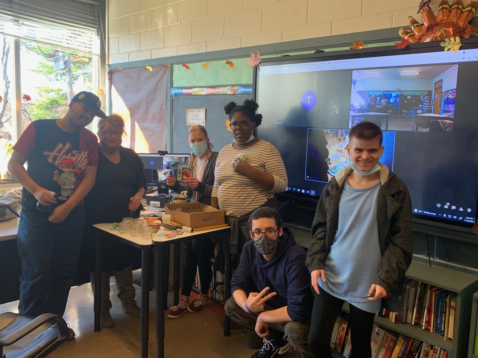 Students and staff pose for a group photo in class with their food project