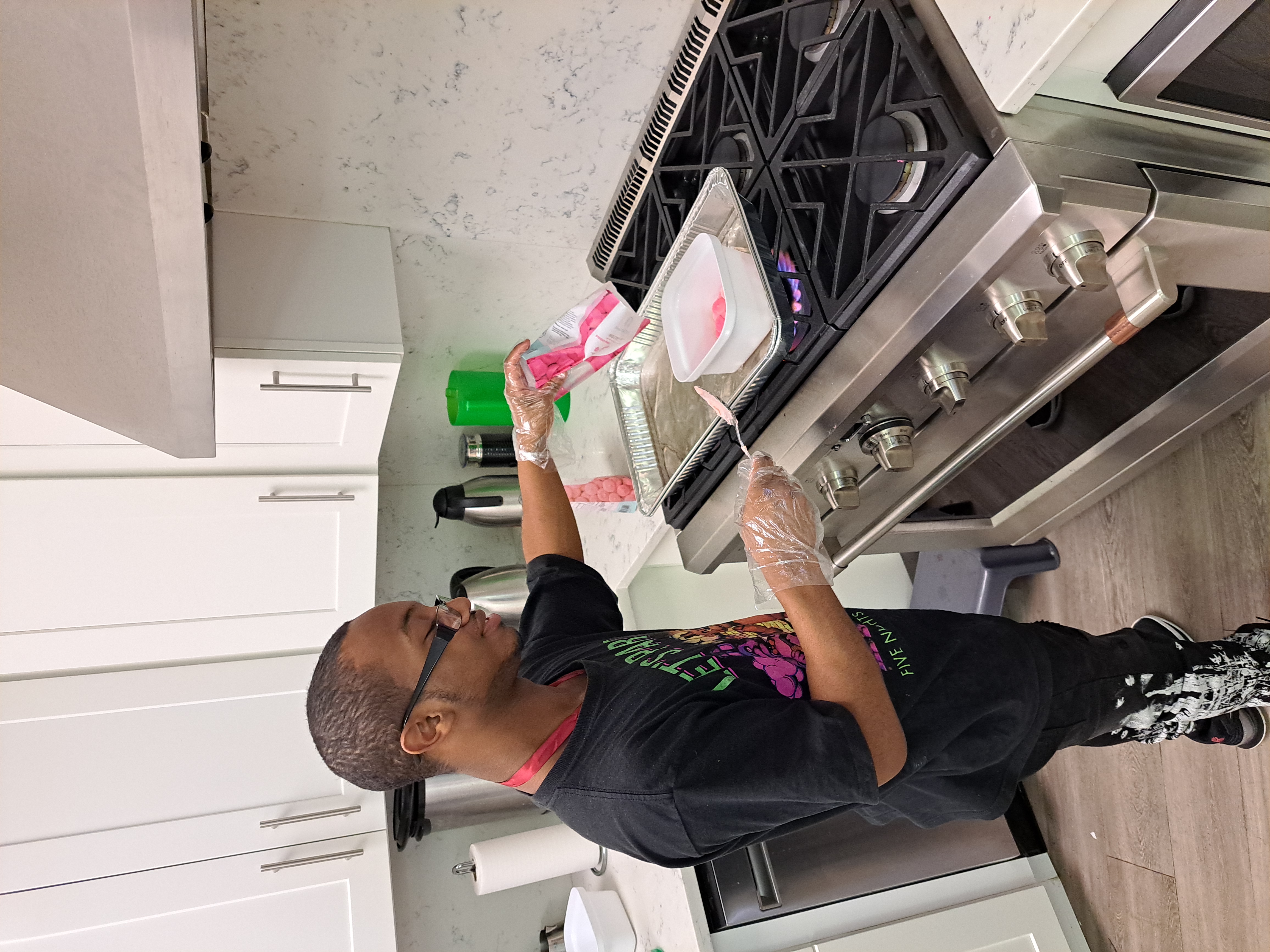 A student stands at a stove cooking