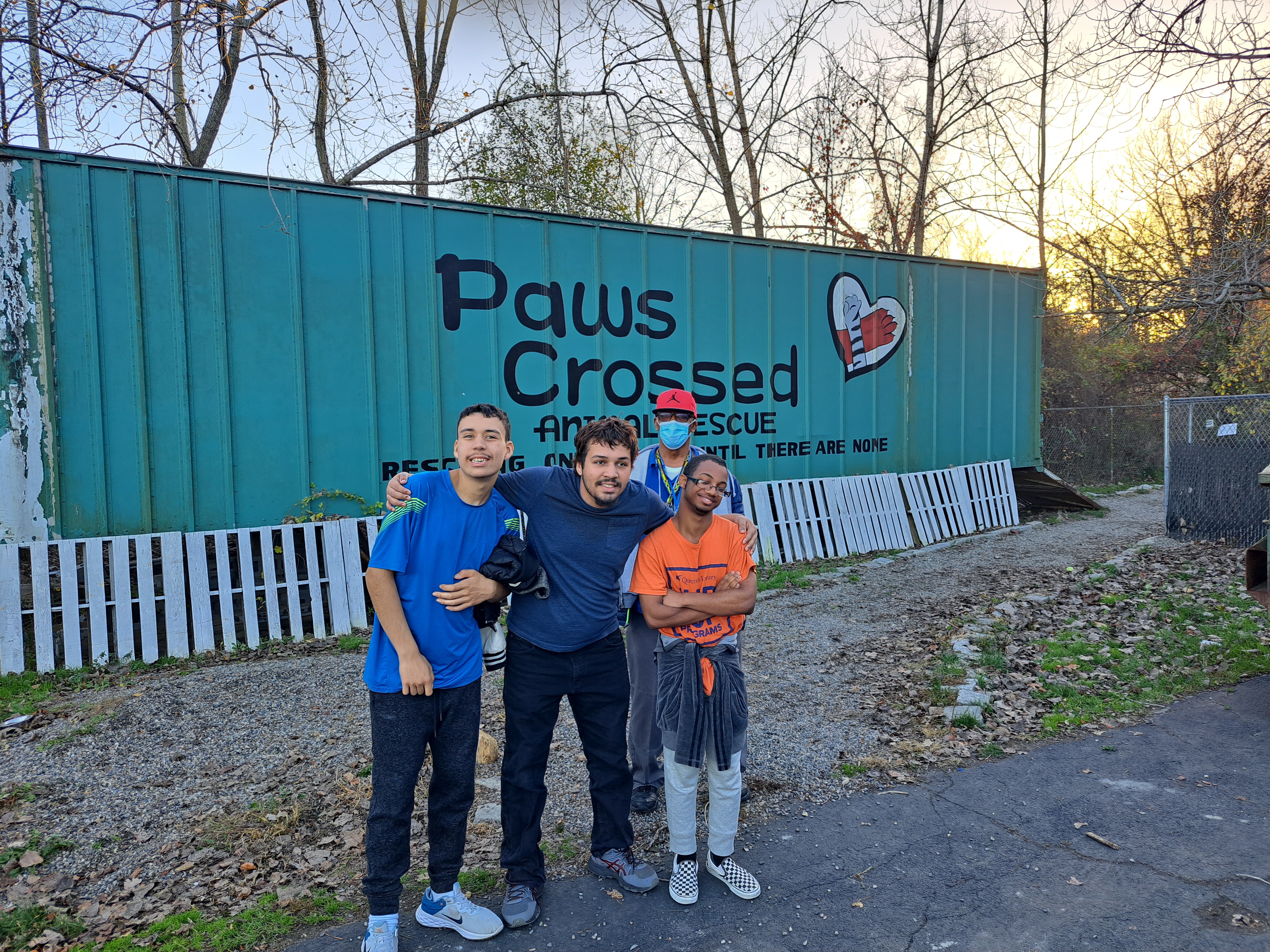 Students pose in front of the paws crossed building 