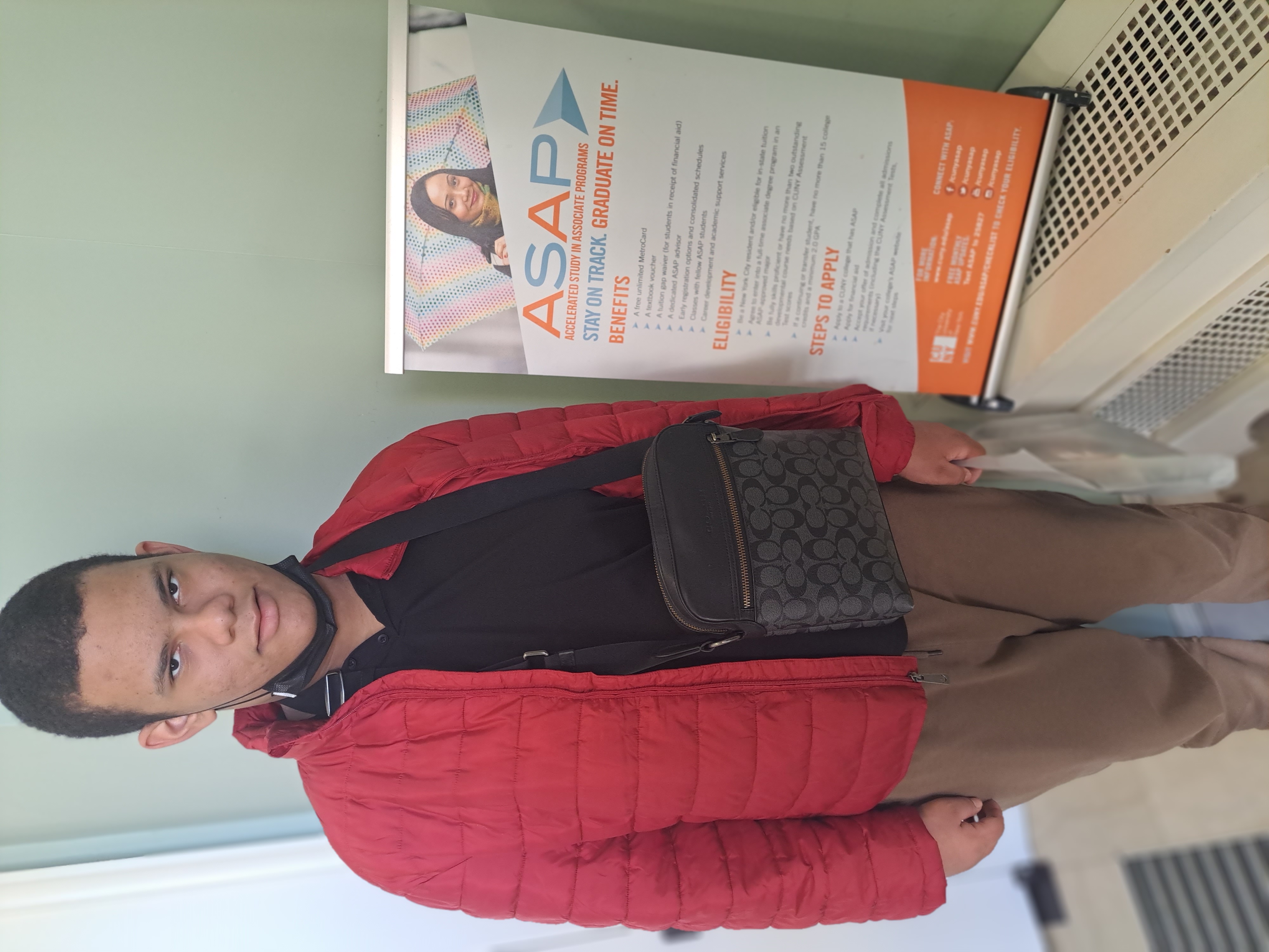 A student poses next to a sign that says "Accelerated study in associate programs"