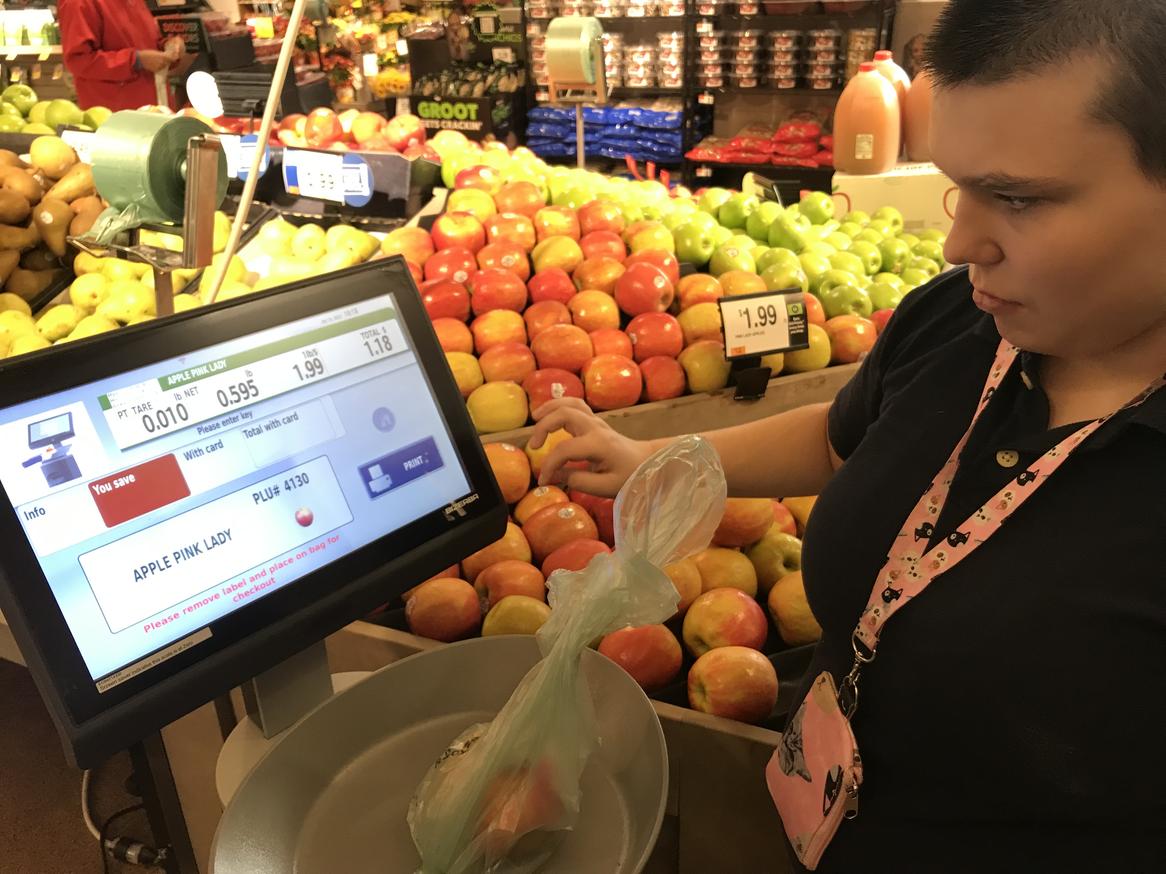 A student weighs fruit at the grocery store