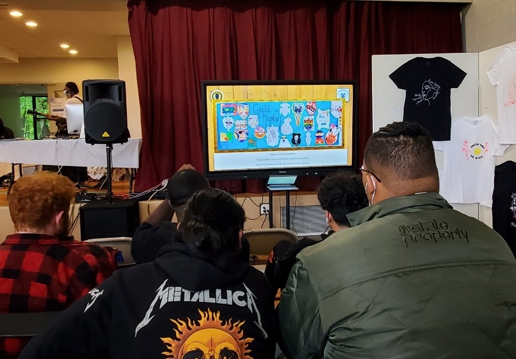 students watching art work on tv display