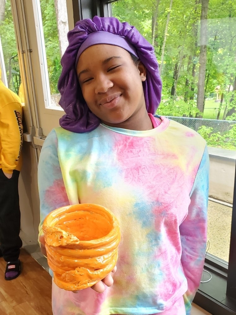 student with yellow art piece