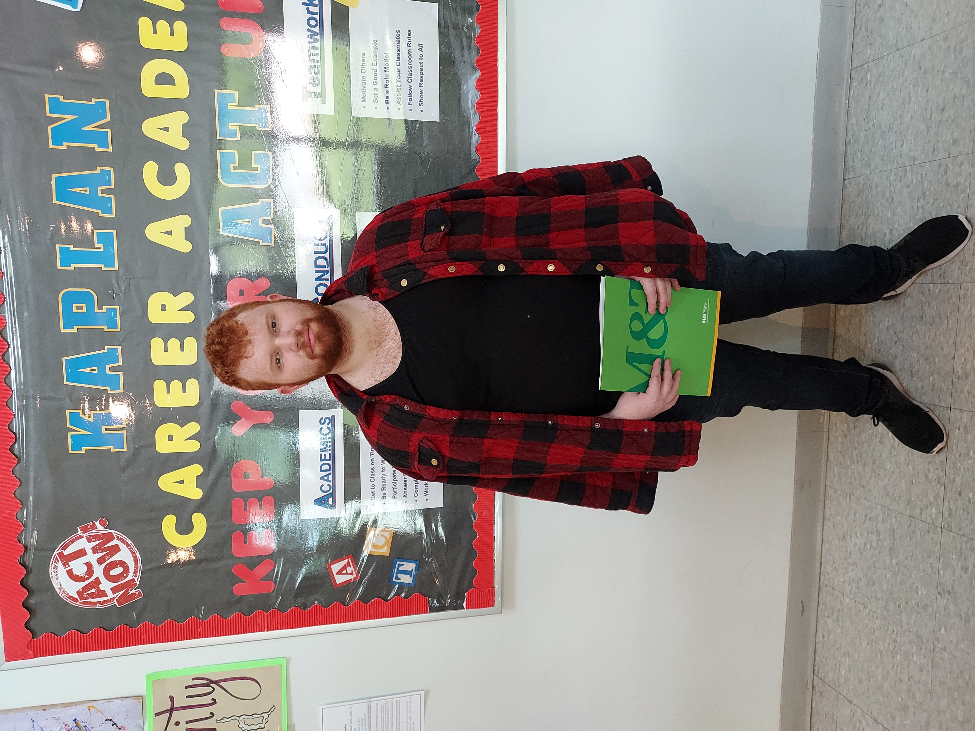 student holding green folder