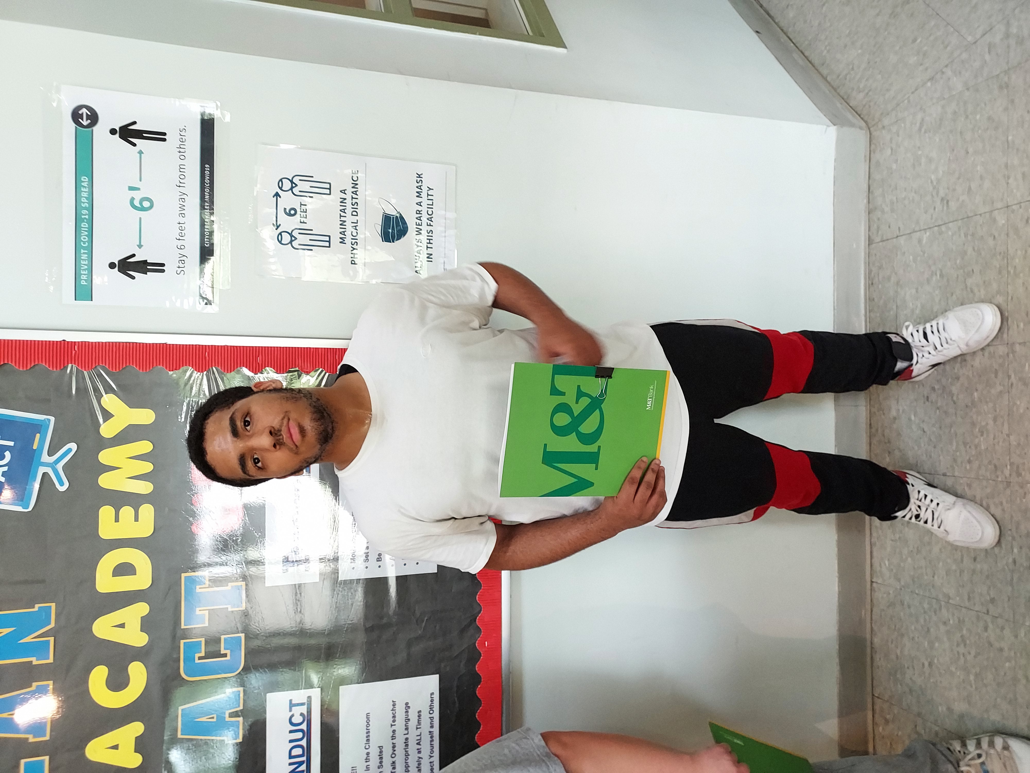 student holding green folder