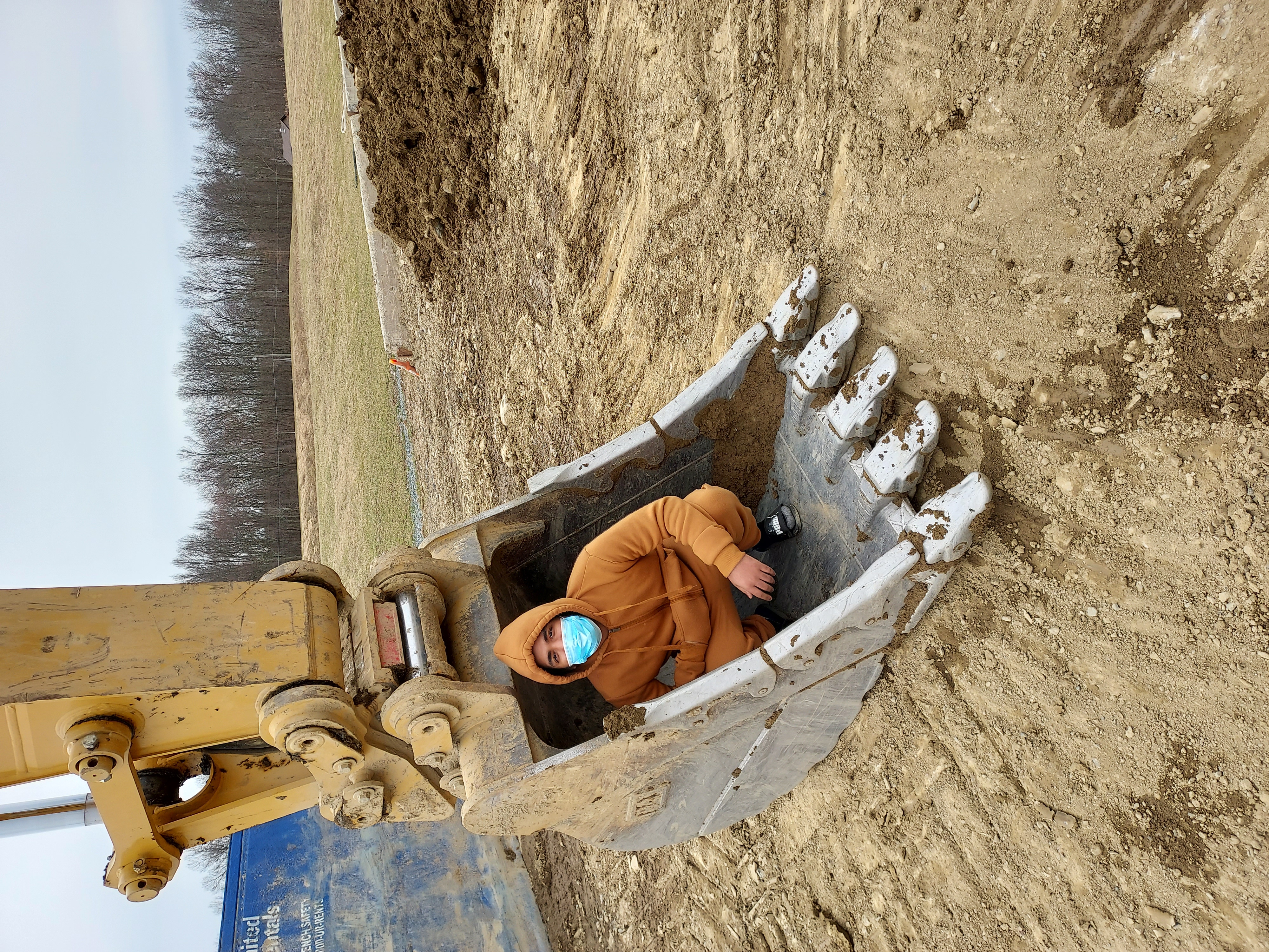student standing next to construction vehicle