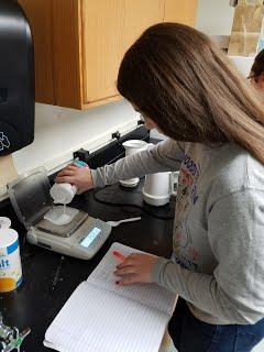 Quincy Fournier measuring materials to prepare solutions for her investigation into specific heat capacity of different substances