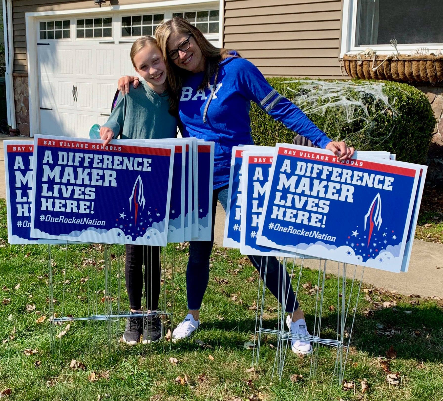 Photo of a PTA volunteer placing signs in staff yards to thank them.