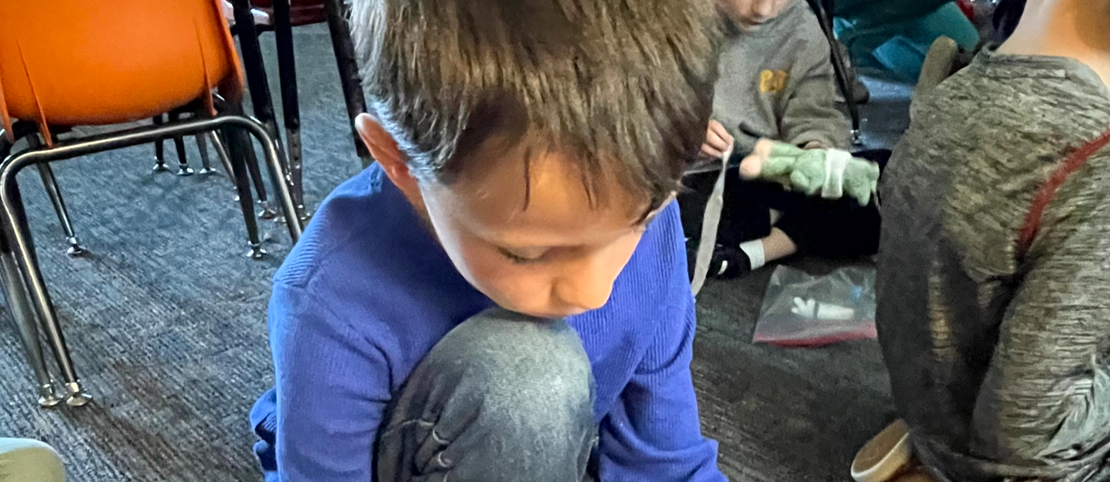 Student examining object as part of class lesson