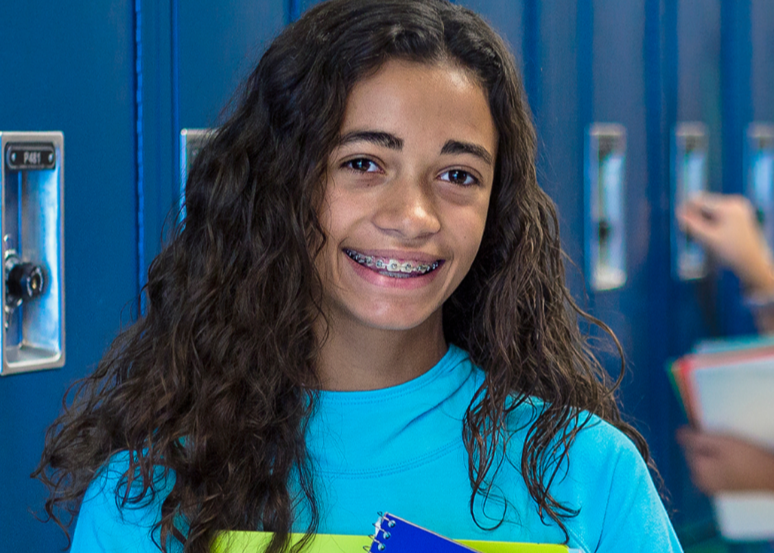 Girl Smiling with Notebook in Hand