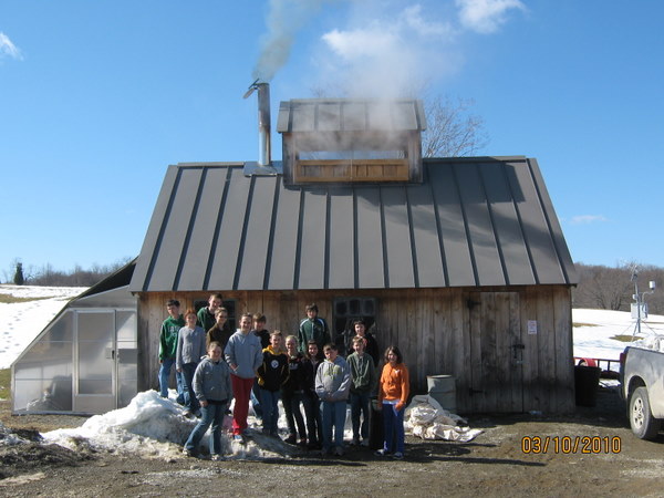 People standing in front of a building with smoke coming out of a chimney