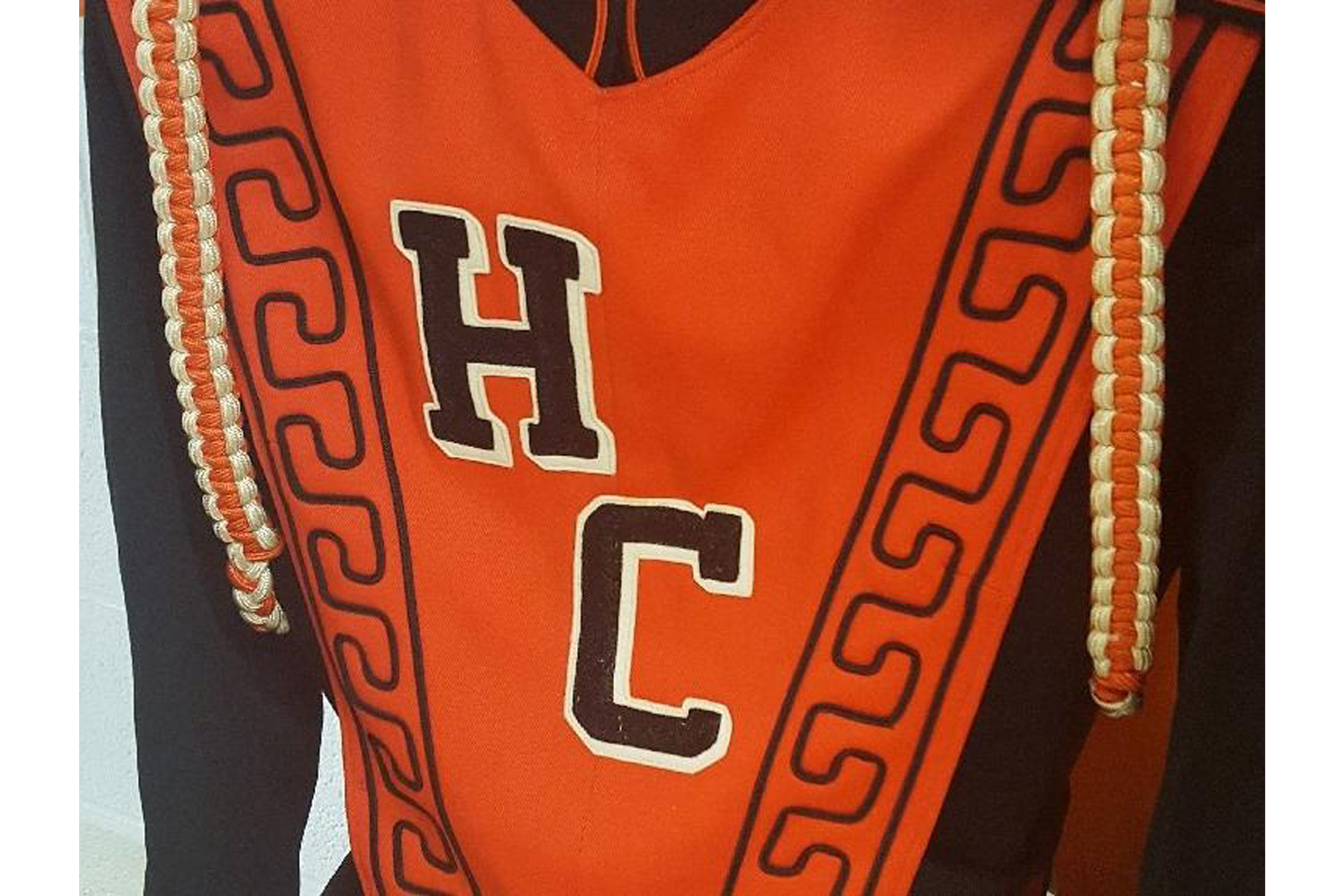 Band uniform with HC in black letter against orange fabric