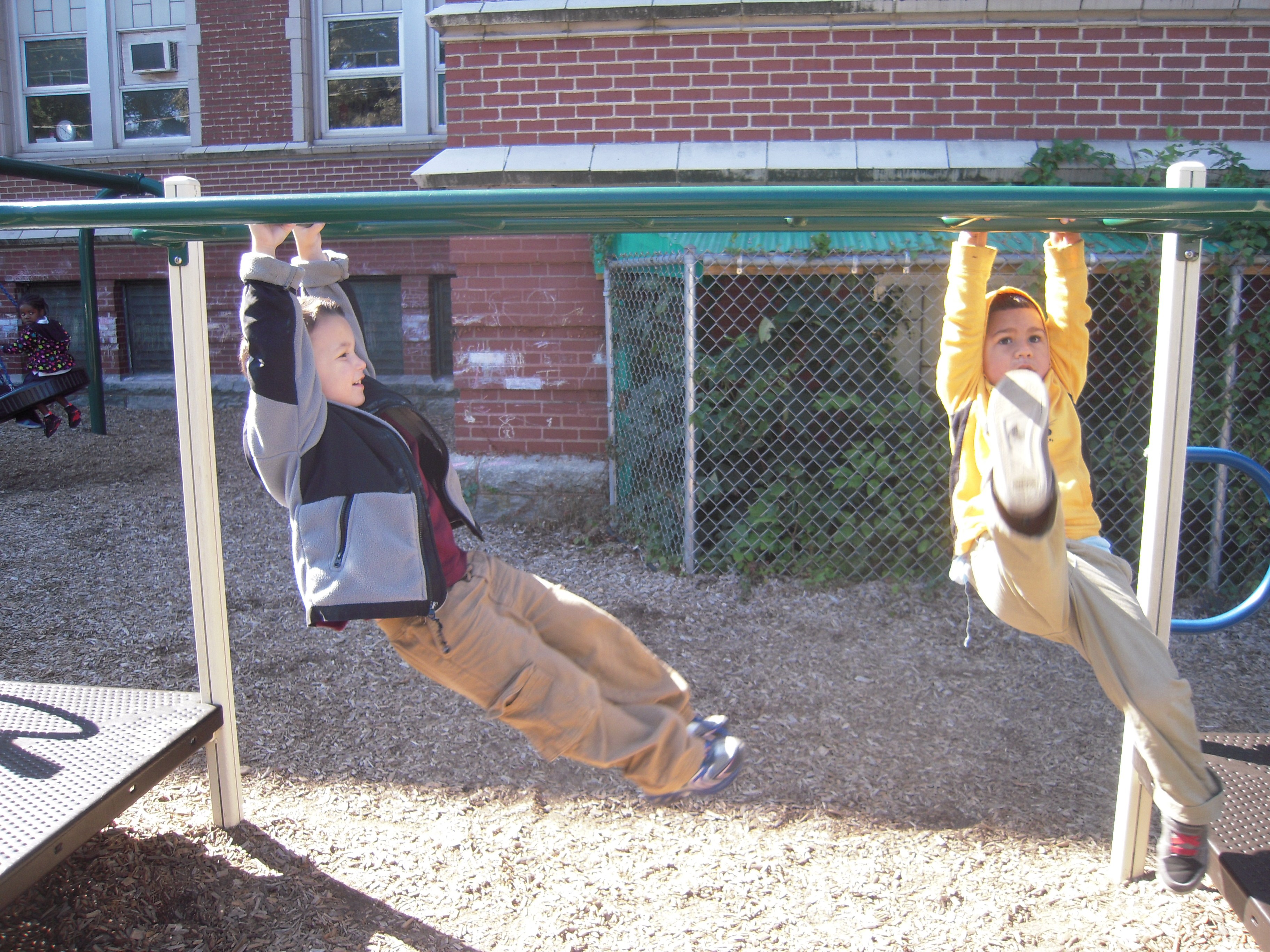 Two young students on playground equipment together