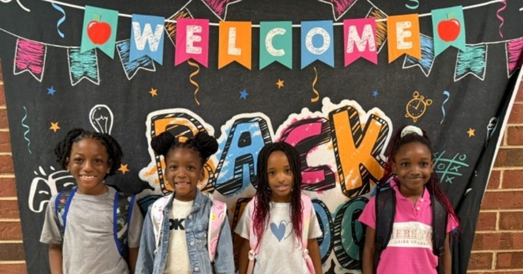 welcome back students in front of sign